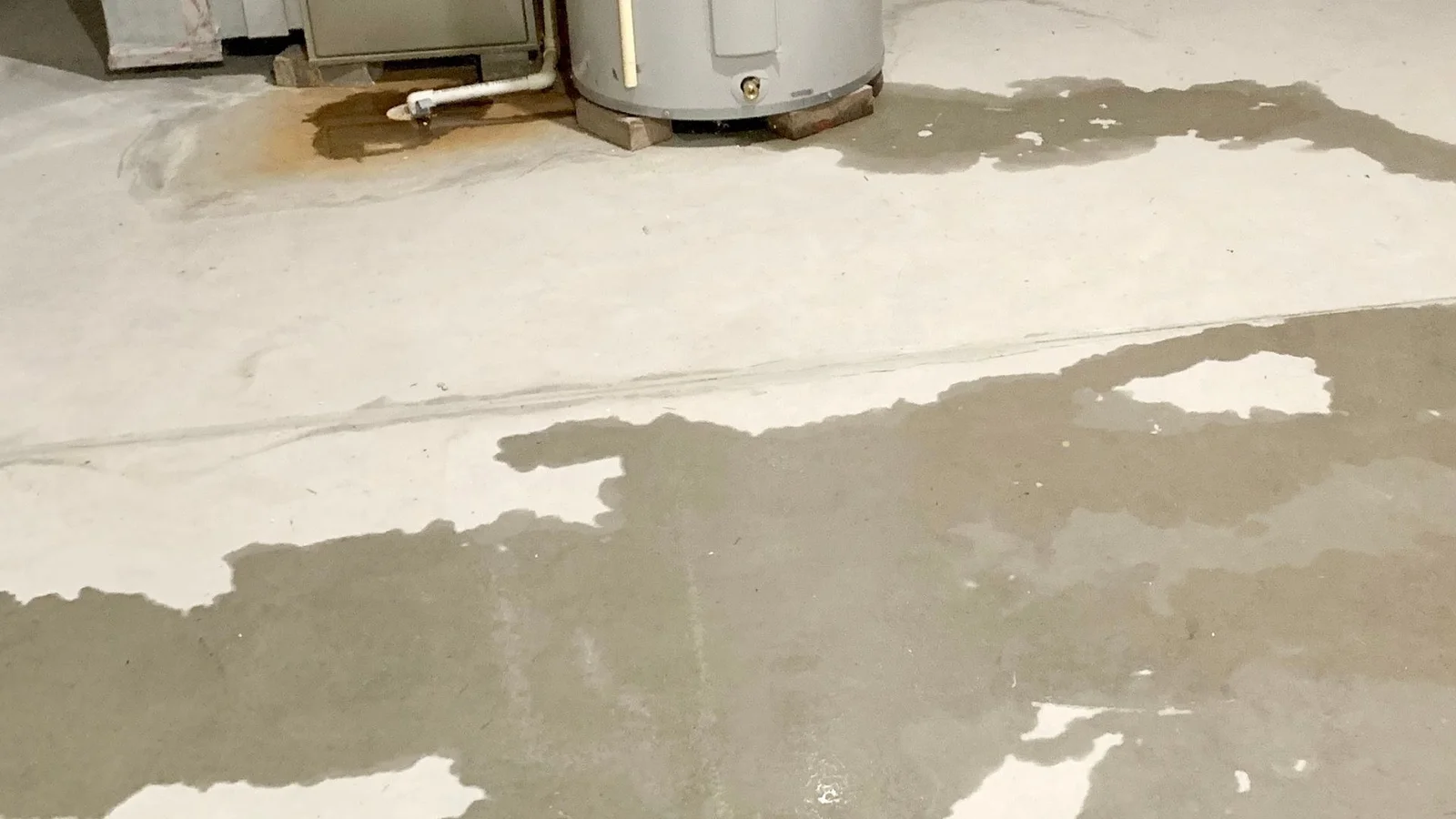 Technician using camera inspection equipment to locate hidden water leak in residential wall