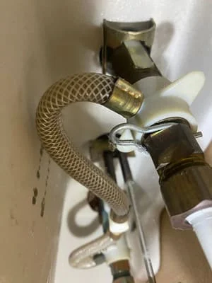 Brass faucet valve with braided stainless steel supply lines and shutoff valves installed under sink