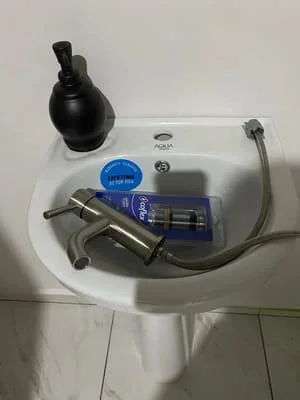 Toilet tank components including fill valve, flush valve, and supply line connections during repair installation