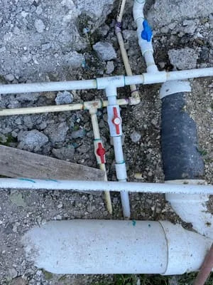 PVC plumbing pipes underground with labeled connections and drainage line installation