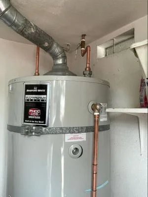 New water heater with copper piping, vent ductwork, and valve connections installed