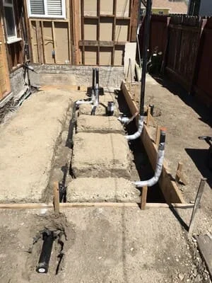 Excavated trench with PVC sewer pipe installation and proper grading