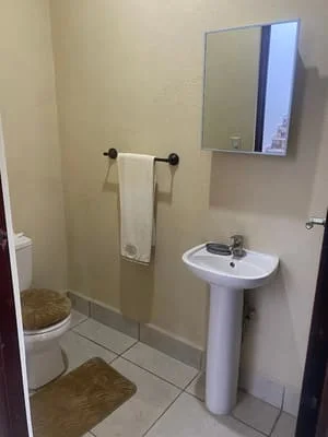 Installed pedestal sink with chrome faucet, towel bar, and ceramic tile bathroom flooring